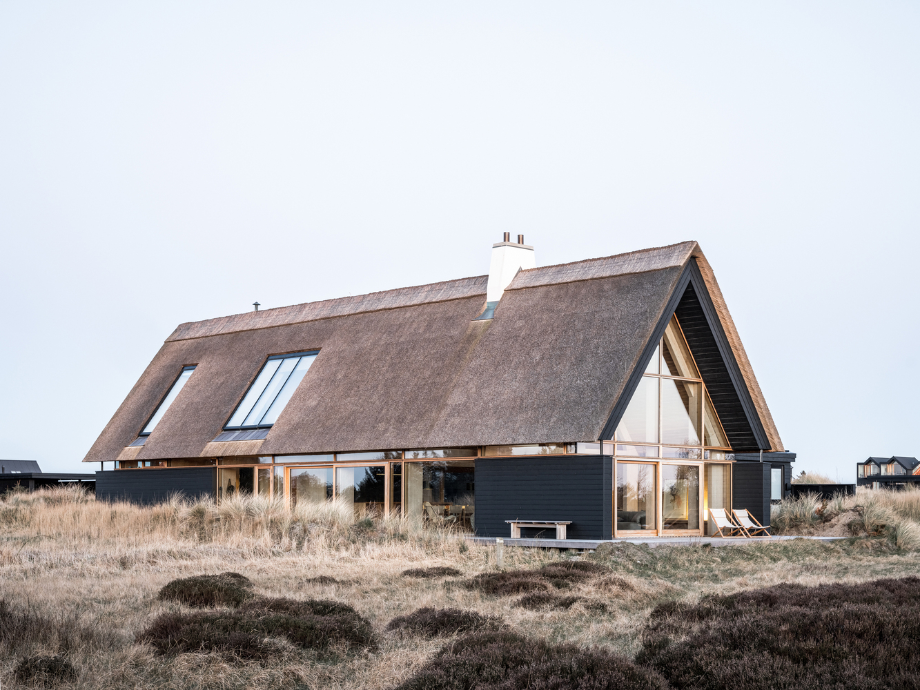 huis zwarte houten gevel rieten dak